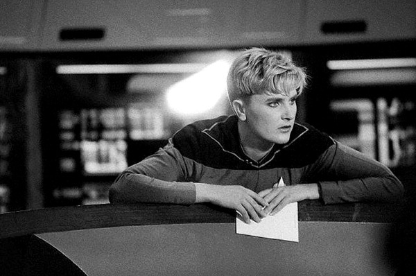 Denise Crosby Tasha Yar leans up against the EnterpriseD's tactical