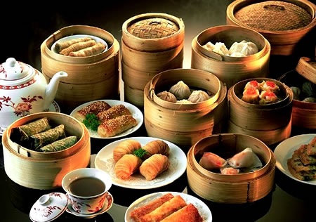 Wooden steamers and plates full of dim sum dishes