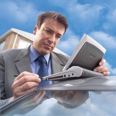 Guy using his netbook, perched on the roof of his car...with a stylus, no less!