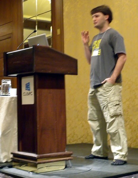 Matt Knox, standing at the lectern, delivering his keynote at CUSEC