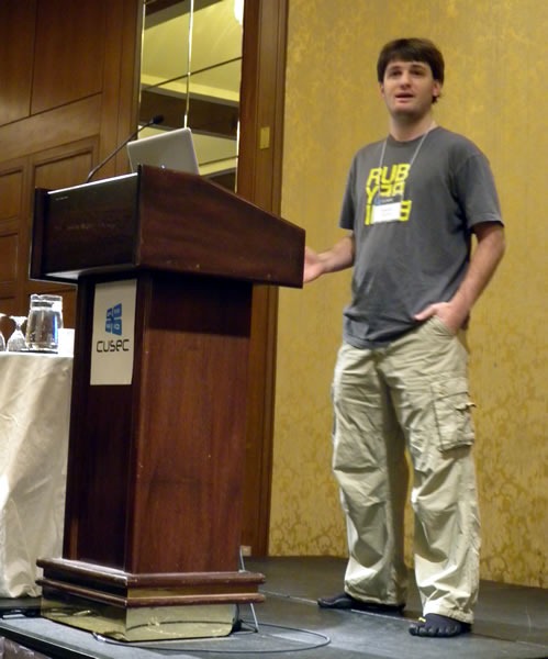 Matt Knox, standing at the lectern, delivering his keynote at CUSEC