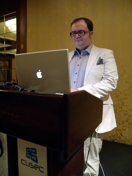Pete Forde, standing at the lectern, giving his keynote at CUSEC 2010