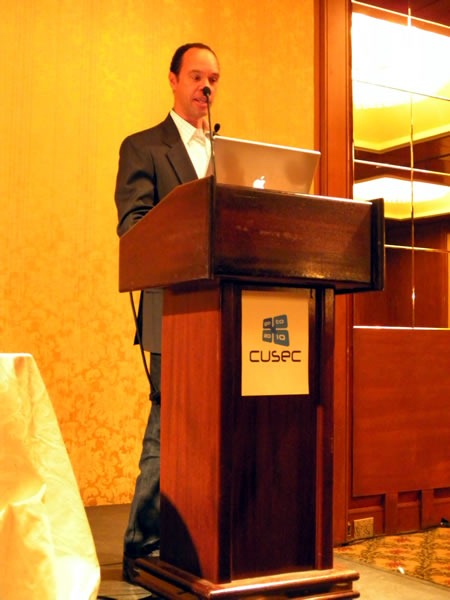 Reg Braithwaite, standing at the lectern, giving his keynote at CUSEC 2010
