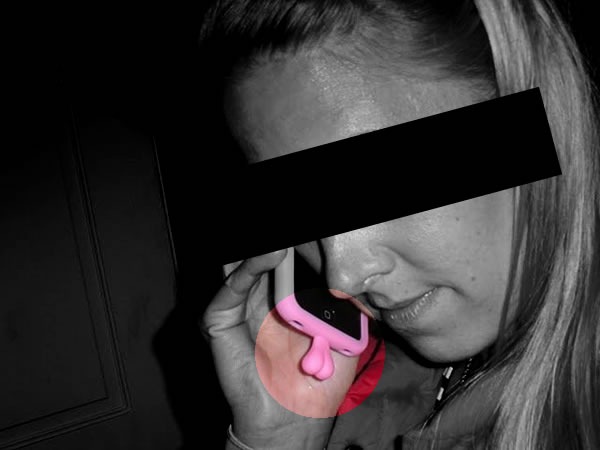 Woman using a phone with a case featuring dangling "testicles"