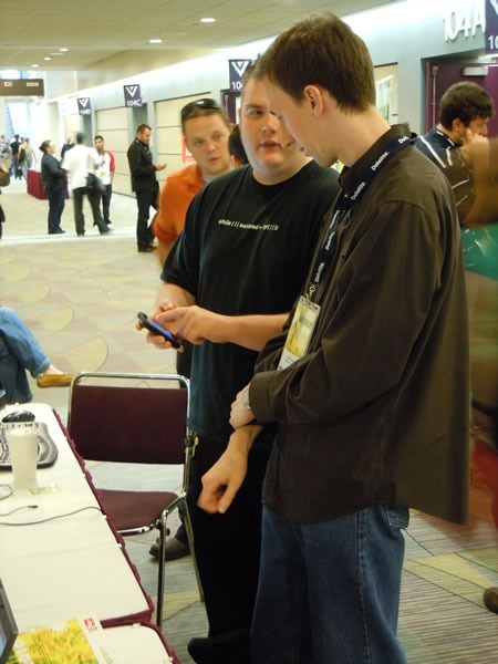 Barranger Ridler and Cory Fowler demonstrating Windows Phone 7 to a booth visitor