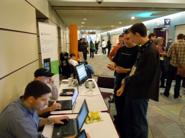 Anthony Vranic and Sean Kearney hack away as Barranger Ridler and Cory Fowler demonstrate Windows Phone 7 to a visitor to the booth