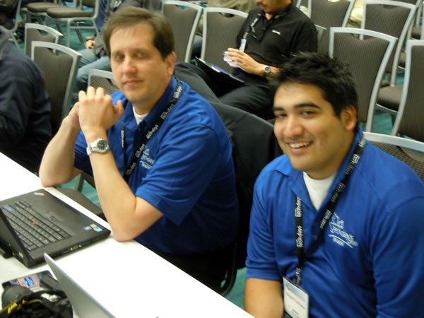 Aaron Kowall and Miguel Carrasco, seated and watching a presentation