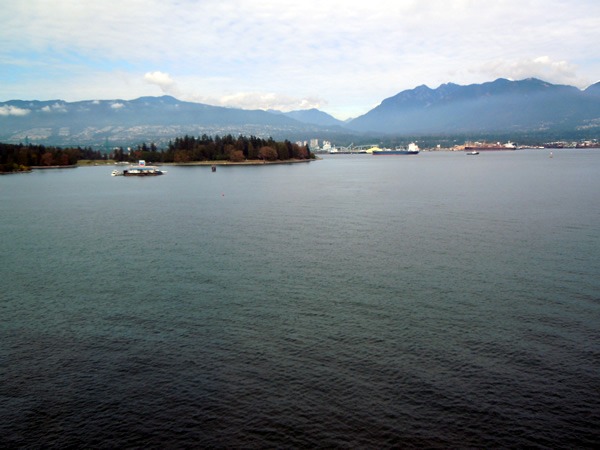 View of the ocean and mountains, with an island with a large sign on the left