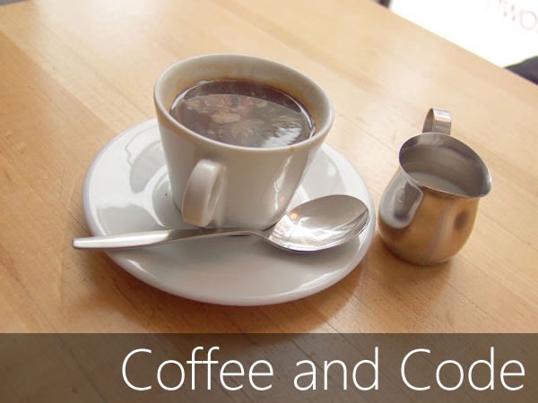 Coffee and Code: Cup of coffee and a milk server on a wooden table