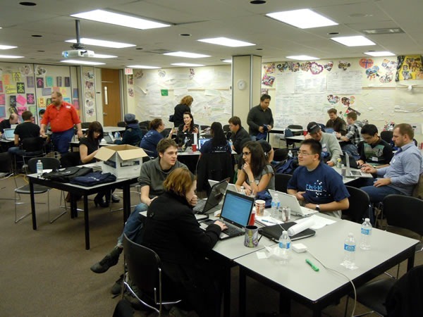 title The main RHoK room as seen from the front, packed with developers working at various tables