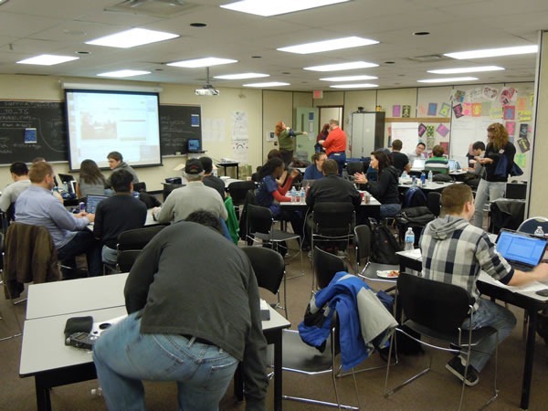 title The main RHoK room as seen from the back, packed with developers working at various tables