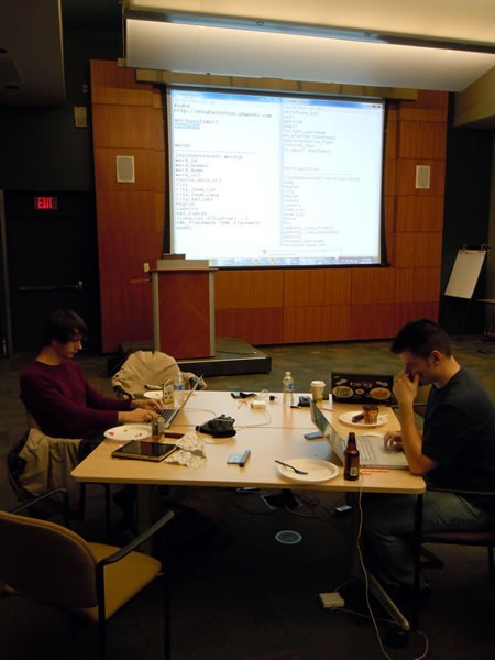 title Two developers working on an open data problem, with a large project in the background
