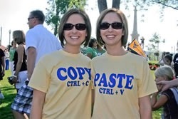 Two women, one wearing a "Copy / ctrl + V" T-shirt, the other wearing a "Paste / ctrl + V" t-shirt