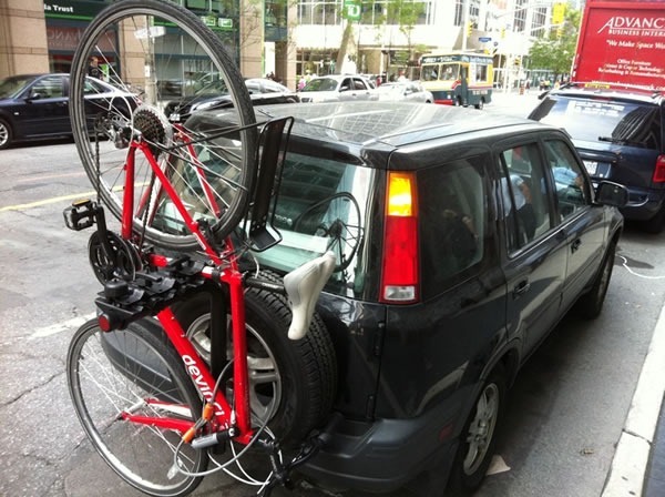 Joey's car (Black Honda CR-V), packed to the gills, with a red bike in the rear-mounted bike rack.