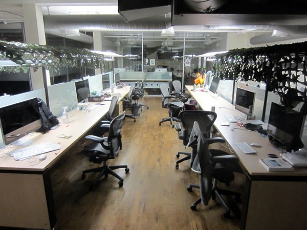 Two rows of empty desks in the centre aisle of Shopify's main office