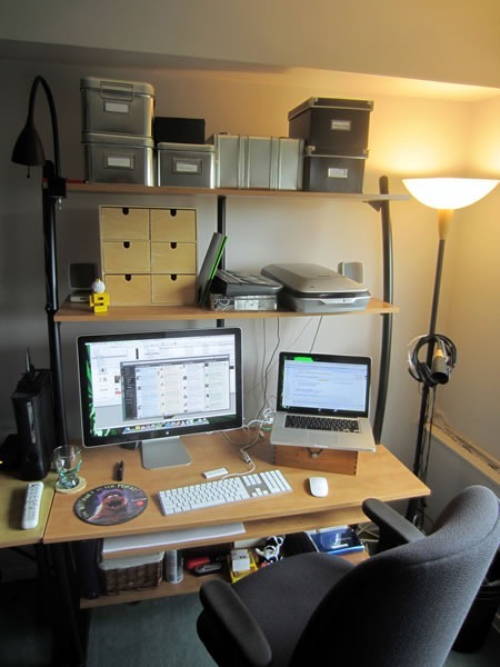 The right side of Joey's workstation, showing a 15" Mackbook Pro, 24" Apple monitor, several organizing containers and a "The Internet is for Porn" mousepad