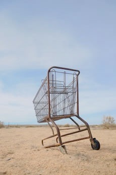 Shopping cart, bogged down in a sand dune