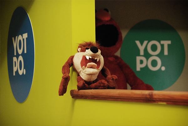 A "Tasmanian Devil" doll, sitting between two Yotpo logos