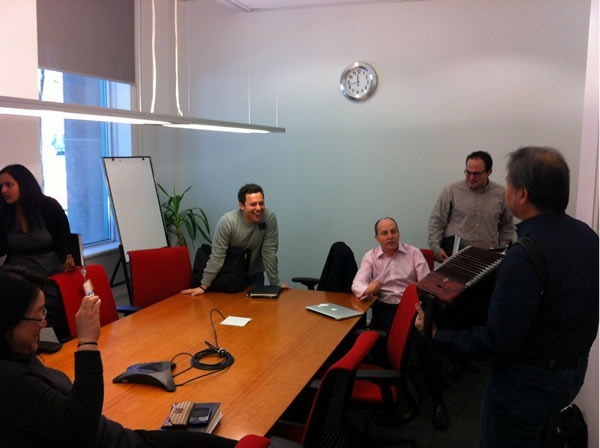 Joey deVilla playing accordion at a business development meeting