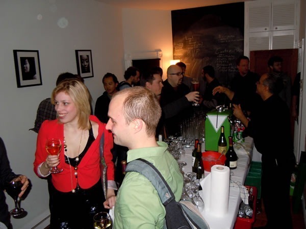 The bar at an Unspace tech gathering, with people enjoying their converation and drinks. It looks like a cocktail party!