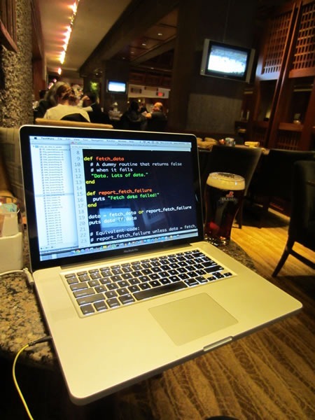 preparing my presentation Joey deVilla's MacBook Pro displaying Ruby code. A pint glass of Rickard's Red is beside it.