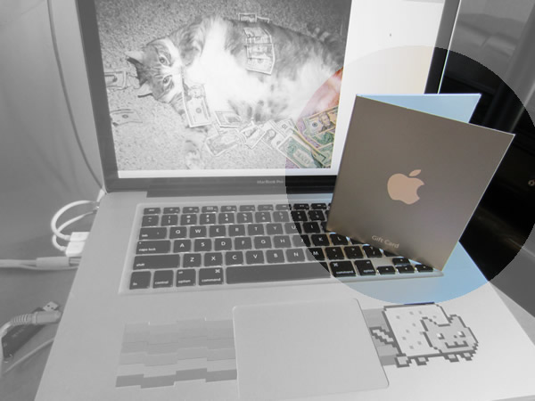 Apple store gift card sitting on a Macbook Pro