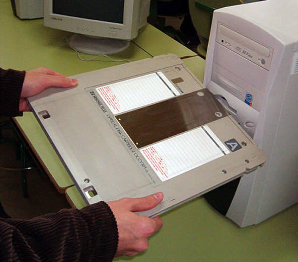 Trying to insert an optical disk cartridge into a tower PC, but the thing's twice the PC's width.
