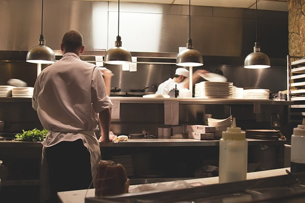 Waiter and cook working in a restaurant.