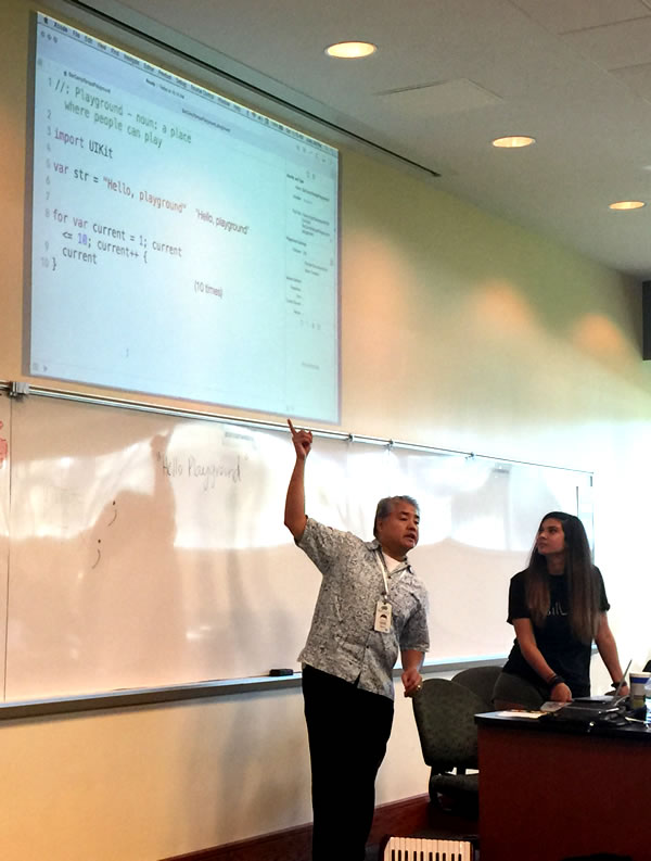 Photo: Joey deVilla points at a projected screen of code with co-presented Angela Don.