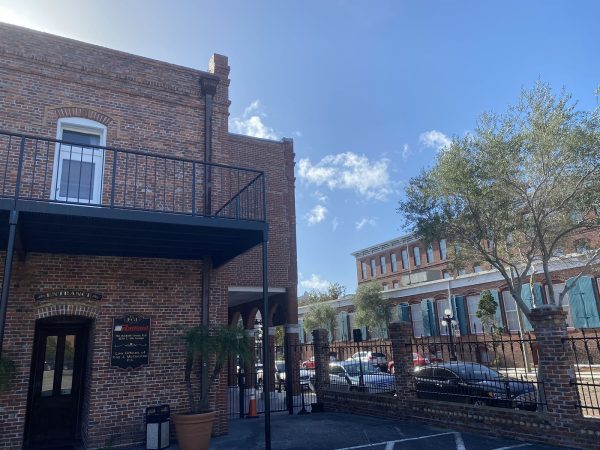 Photo: A red brick building with a wrought iron balcony in a neighborhood of early 1900s brick buildings.