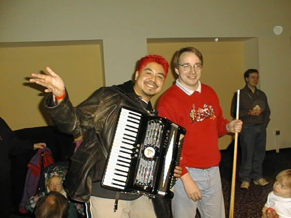 Photo: Joey deVilla, with his accordion, poses with Linus Torvalds, who is holding a pool cue.