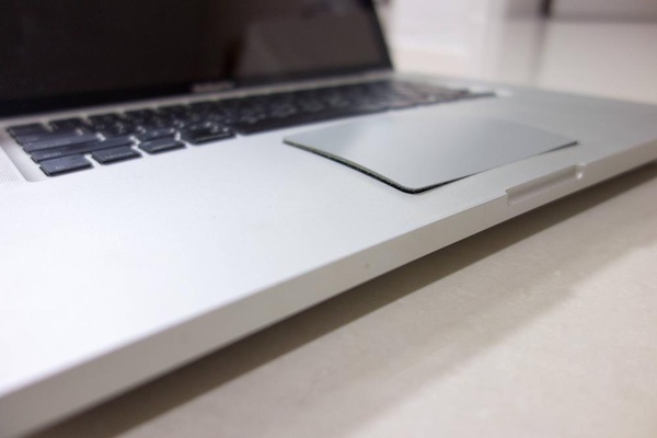 Close-up photo of a MacBook trackpad popping out of alignment de to a bulging battery