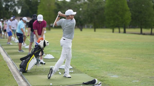 Golfers at the Tampa Bay Tech Golf Classic practicing on the driving range