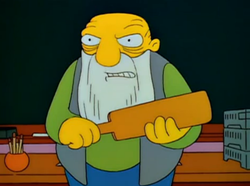Jasper from “The Simpsons,” glowering and holding a paddle.