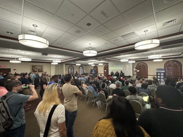 A packed main room at CyberX Tampa Bay, with every seat full and lots of people standing.