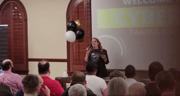 Suzanne Ricci at the front of the main room at CyberX Tampa Bay, delivering an opening speech.